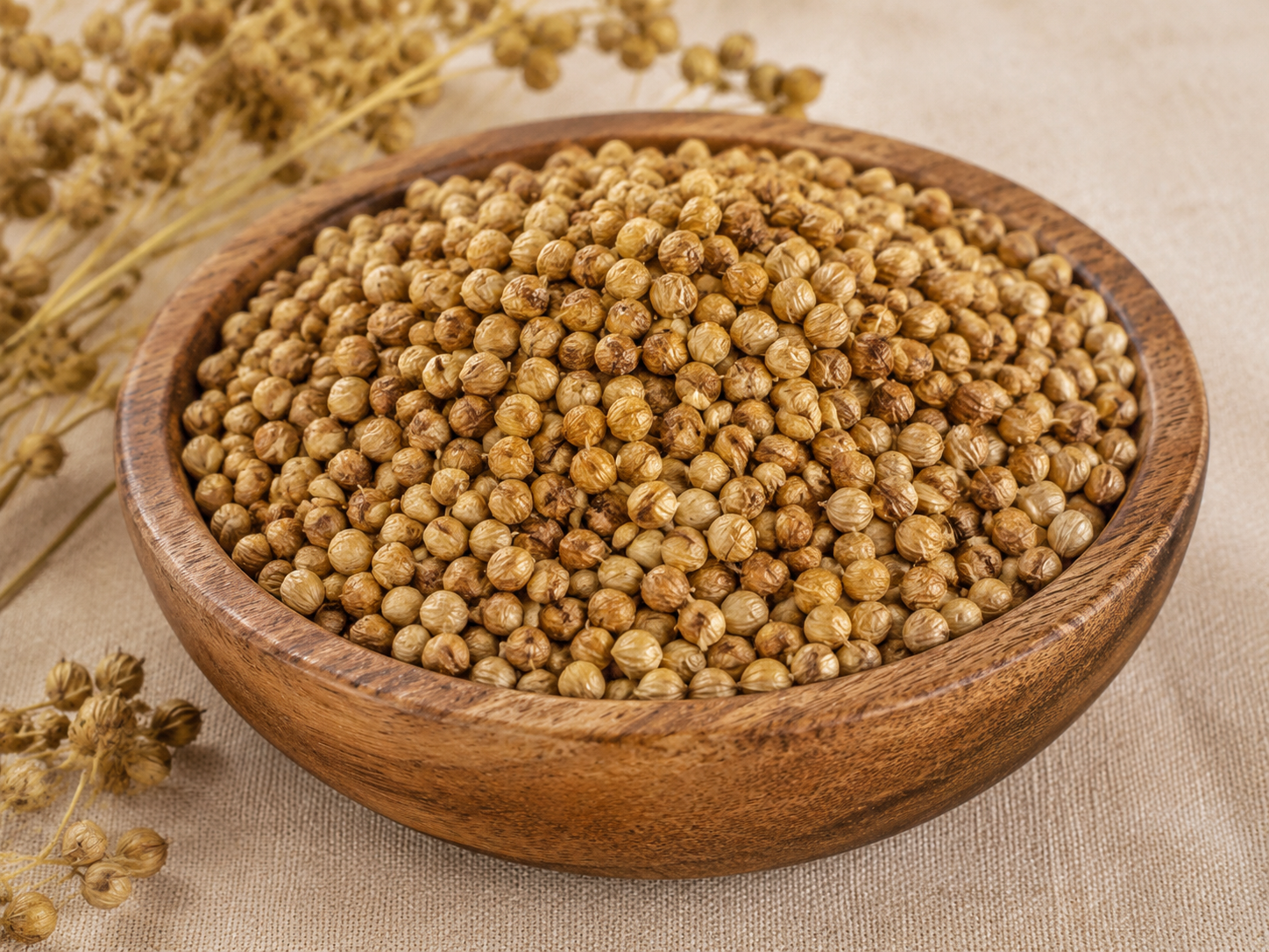 Whole coriander seeds in a wooden bowl